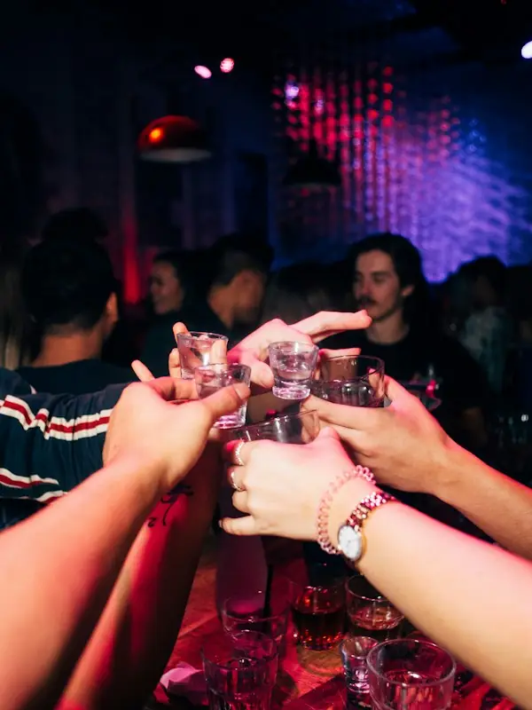 Friends clinking glasses over a bar table