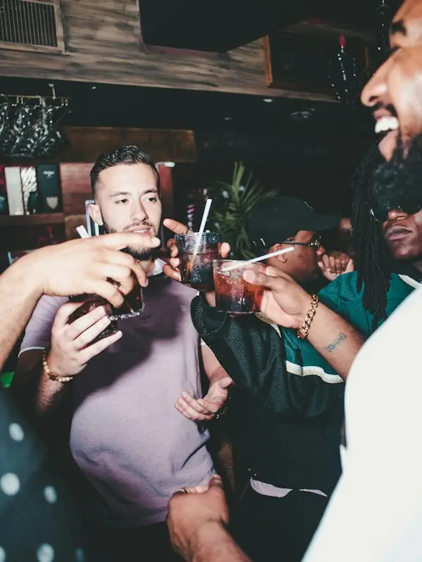 Friends toasting drinks in a busy bar