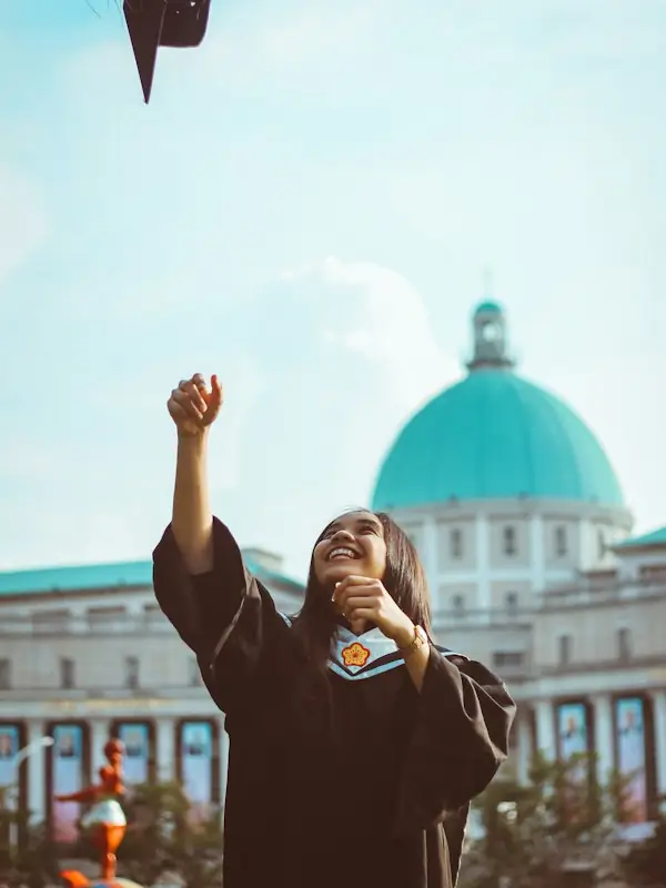 A graduate throwing her cap in the air